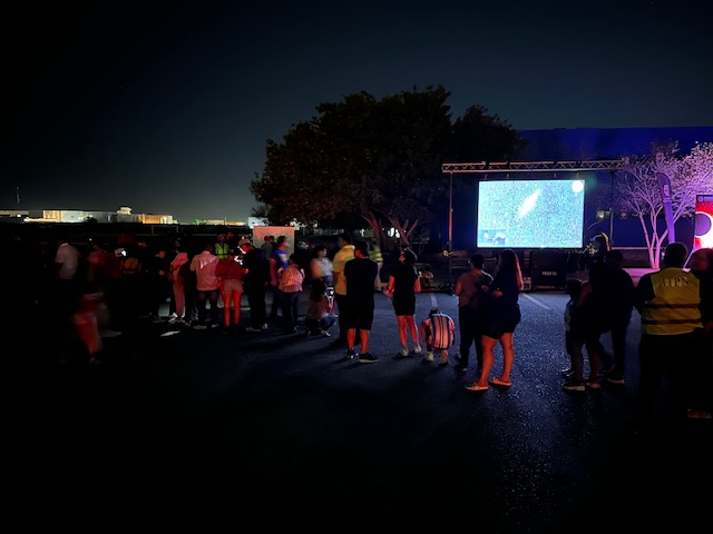 Same crowd of people looking up at the sky, but now it is dark