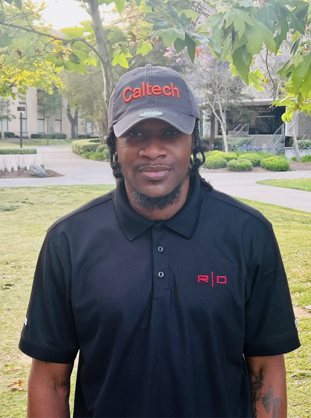 Photo of Manager Deveon Howard, standing on the lawn outside Red Door with a smile on his face.
